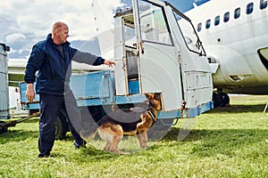 Security officer and detection dog checking truck at aerodrome