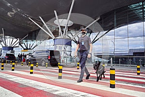 Security officer with detection dog crossing the road at airport