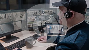 Security officer in headset controls CCTV cameras