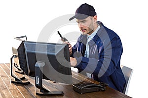 Security officer looking at computer monitors and talking on walkie-talkie