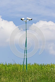 Security videocamera on green field