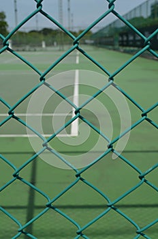 Security wire mesh fence with blurred tennis court background