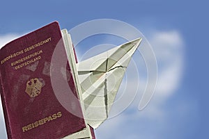 Sed passport from Germany with a paper airplane against the blue