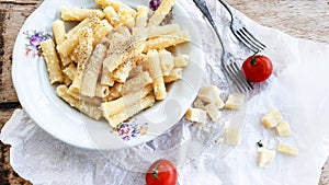 Sedani rigati pasta cacio e pepe with cherry tomatoes and parmesan cheese