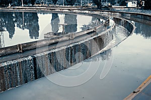 Sedimentation round tank in modern sewage or wastewater treatment plant, blue toned