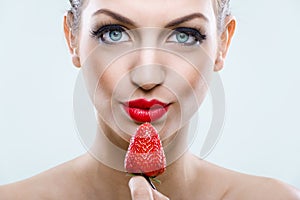 Seduction - Beautiful eyed woman holding a strawberry