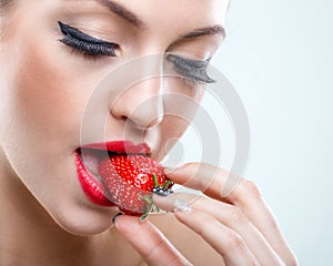 Seduction - Beautiful woman when closed eyes, take a bite of the strawberry