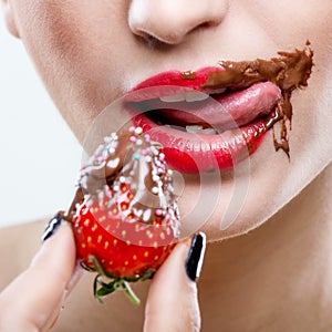 Seduction - red female lips with chocolate mouth , holding strawberries