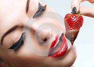 Seduction - red female lips eating chocolate strawberries