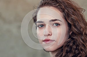 Seductive beautiful curly girl, portrait on gray background