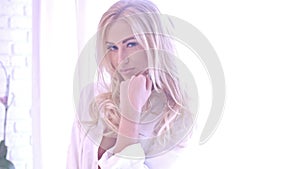 Seductive Blond Woman in White Looking at Camera