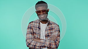 Seductive cheerful stylish african american man wearing sunglasses, charming smile on gray wall