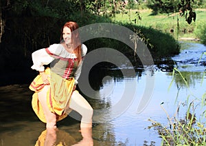 Seductive girl in historical dress in water