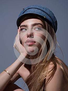 Seductive woman face. Sensual young woman posing in fashion cap hat. Beautiful sexy model. Beauty face. Sensual girl