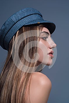 Seductive woman face. Sensual young woman posing in fashion cap hat. Beautiful sexy model. Beauty face. Sensual girl