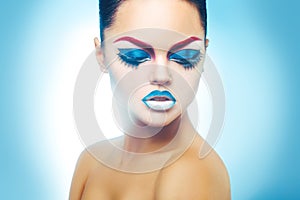 Seductive woman with healthy skin and make up on blue background