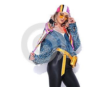 Seductive woman holding headscarf and fixing yellow sunglasses l