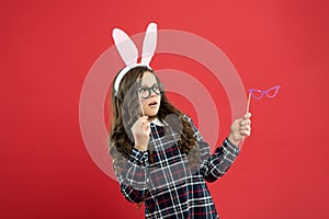 See better. funny little girl in rabbit ears. happy childhood. surprised kid hold party glasses. spring holiday