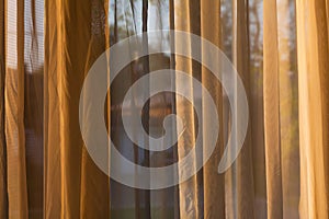 See through curtain by the window with outside view at dusk