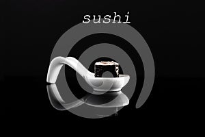 Sushi 0n white spoon with black background. photo