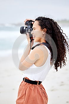 See the world through my lens. a young woman taking pictures at the beach.