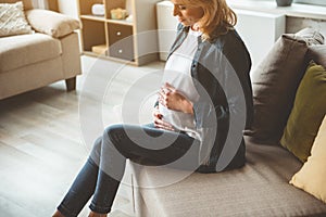 Peaceful pregnant woman touching her abdomen