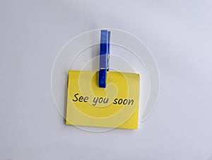 See you soon written on clipped yellow note