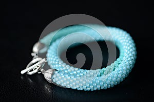 Seed bead necklace aquamarine color on a dark background