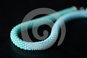 Seed bead necklace aquamarine color on a dark background