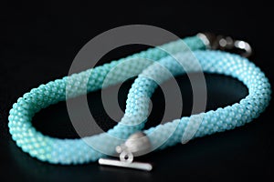 Seed bead necklace aquamarine color on a dark background