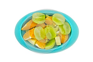 Seedless grapes orange kiwi apples cut in pieces in blue oval photo