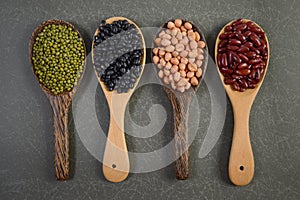 Seeds beansBlack Bean, Red Bean, Peanut and Mung Bean useful for health in wood spoons on grey background