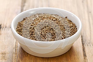 Seeds of carum in white bowl