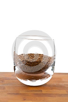 Seeds of dried caraway in glass on wooden table