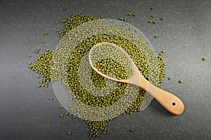 Seeds mung beans useful for health in wood spoons on grey background