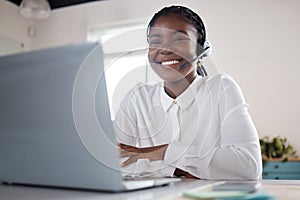 Seeing you smile brings me joy. a young businesswoman using a headset and laptop in a modern office.