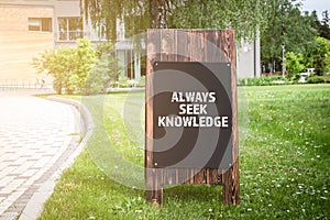 Always Seek Knowledge. Wooden advertising banner on the street