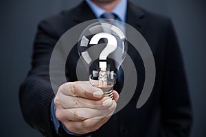 Seeking answers person holds light bulb with question mark symbol