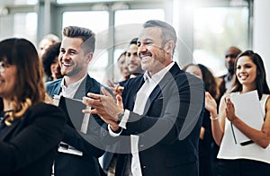 They seemed to have enjoyed it. a group of businesspeople applauding during a seminar in the conference room.