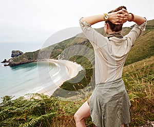 Seen from behind woman hiker enjoing ocean view landscape