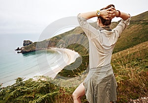 Seen from behind woman hiker enjoing ocean view landscape photo