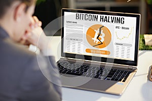 Seen from behind woman with laptop and bitcoin halving screen