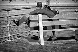 Seen from behind, Young Couple on a bench on a pier