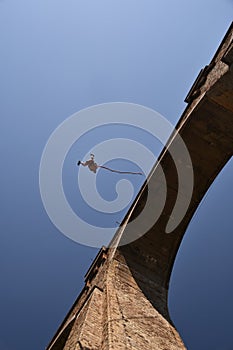 Young man bungee jumper hanging on a cord