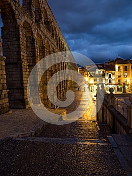 Segovia, Spain at the ancient Roman aqueduct. The Aqueduct of Segovia, located in Plaza del Azoguejo, is the defining historical f photo
