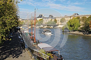 Seine river docks and boats with Louvre Museum in background