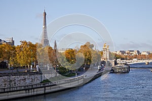 Seine river view with docks, Eiffel tower and Alexander III bridge in a sunny day in Paris