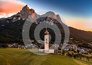Seis am Schlern, Italy - Aerial view of St. Valentin Church and famous Mount Sciliar mountain at background at sunset