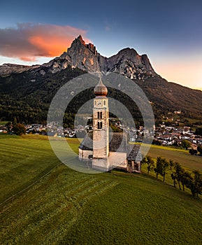 Seis am Schlern, Italy - Aerial view of St. Valentin Church and famous Mount Sciliar mountain at background at sunset