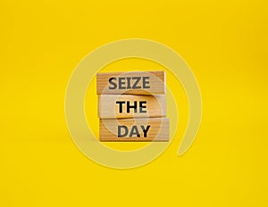 Seize the day symbol. Wooden blocks with words Seize the day. Beautiful yellow background. Business and Seize the day concept.